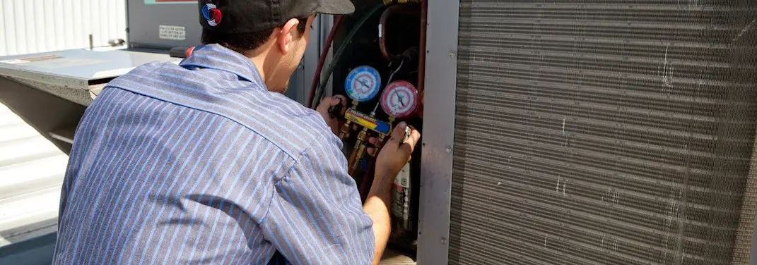 HVAC technician servicing a condenser unit in Little Ferry